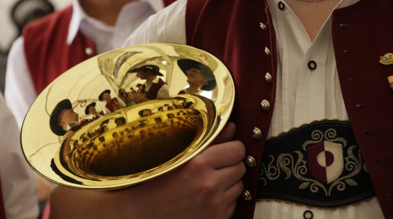 Ein Blechblasinstrument im Arm eines Musikers in Trachtenkleidung