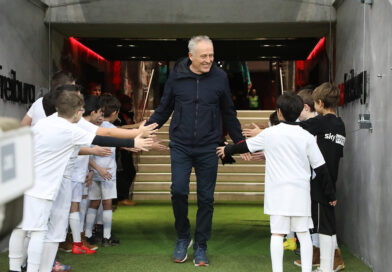 Christian Streich, der ehemalige Trainer des SC Freiburg begrüßt Kinder in Fußballkleidung