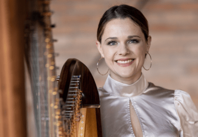 Die festlich gekleidete Musikerin Annalena Storch mit einer Harfe