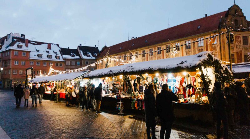 beleuchtete Weihnachtsmarktstände auf dem Memminger Marktplatz in der Dämmerung